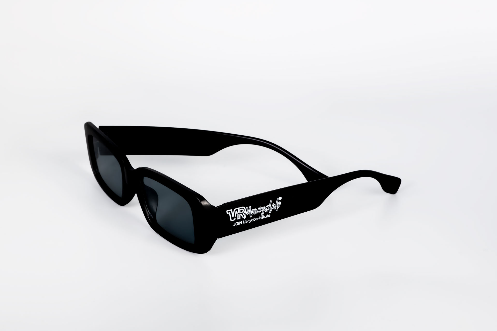 Schwarze, rechteckige Sonnenbrille im Retro-Look mit weißem „VR Moneyclub“ Logo und der Aufschrift „JOIN US: yoba-hsh.de“ auf dem breiten Bügel, freigestellt vor weißem Hintergrund.